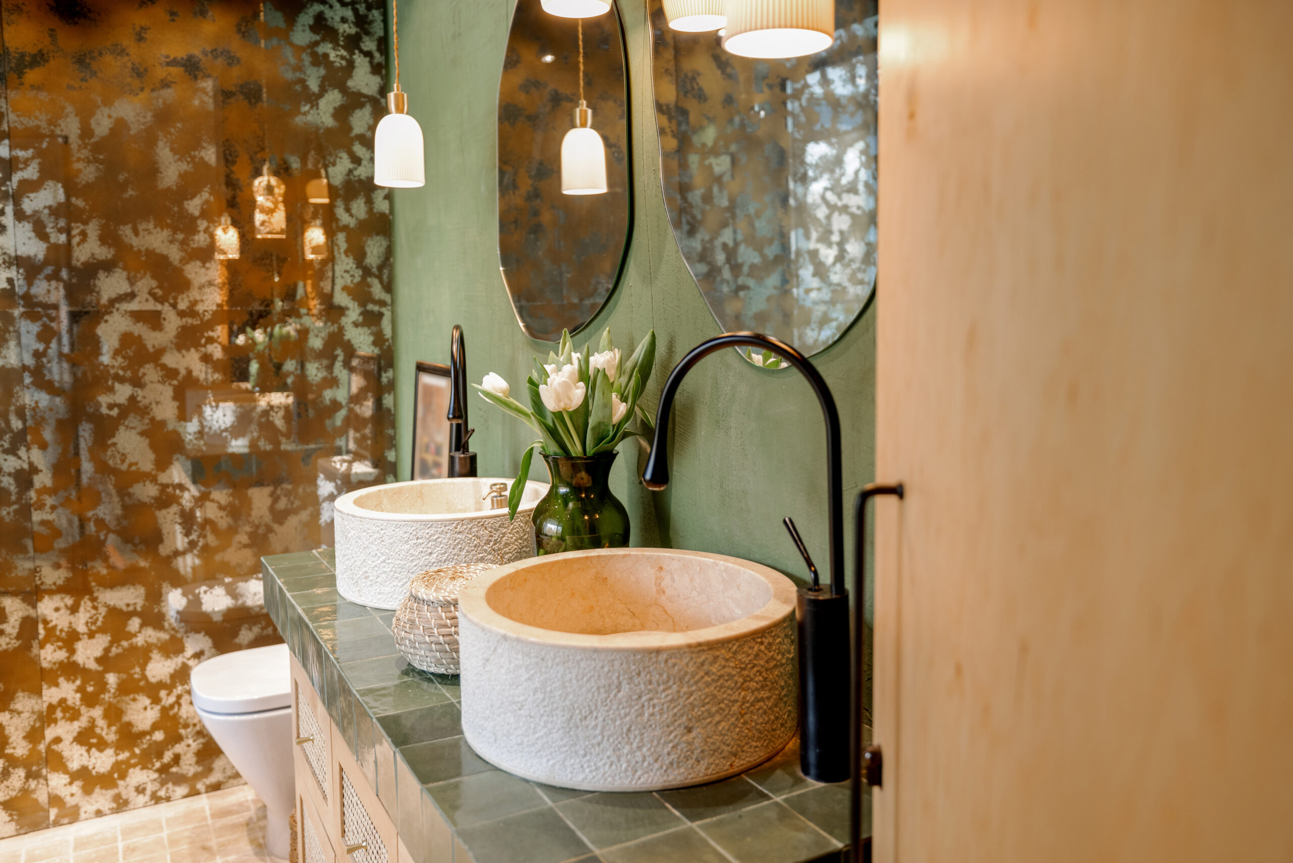 A luxurious bathroom in Denver featuring vanity lighting, wall-mounted sconces, and moisture-resistant LED ceiling lights