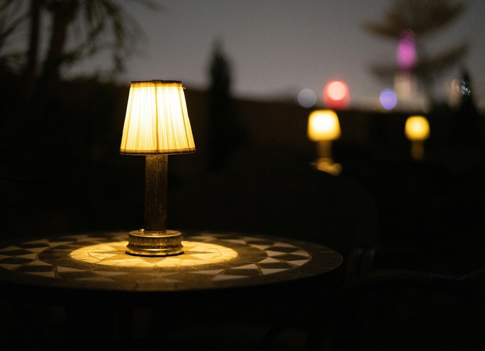 Outdoor garden lights on a patio table showing when to change landscape lights for better nighttime ambiance.